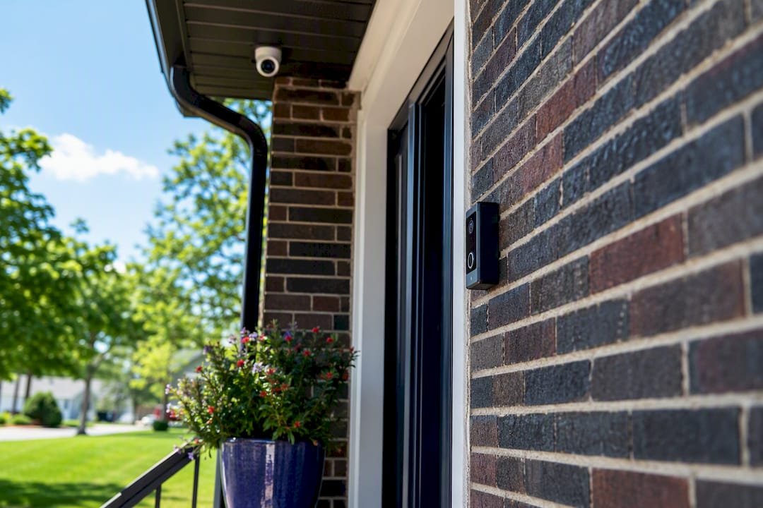 Video doorbell and under-eaves security camera at porch